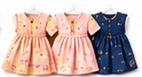 Three doll dresses on hangers: peach, pink and navy